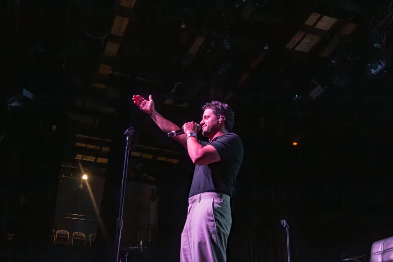 Gabriel Hidalgo cantando con una mano extendida hacia el público